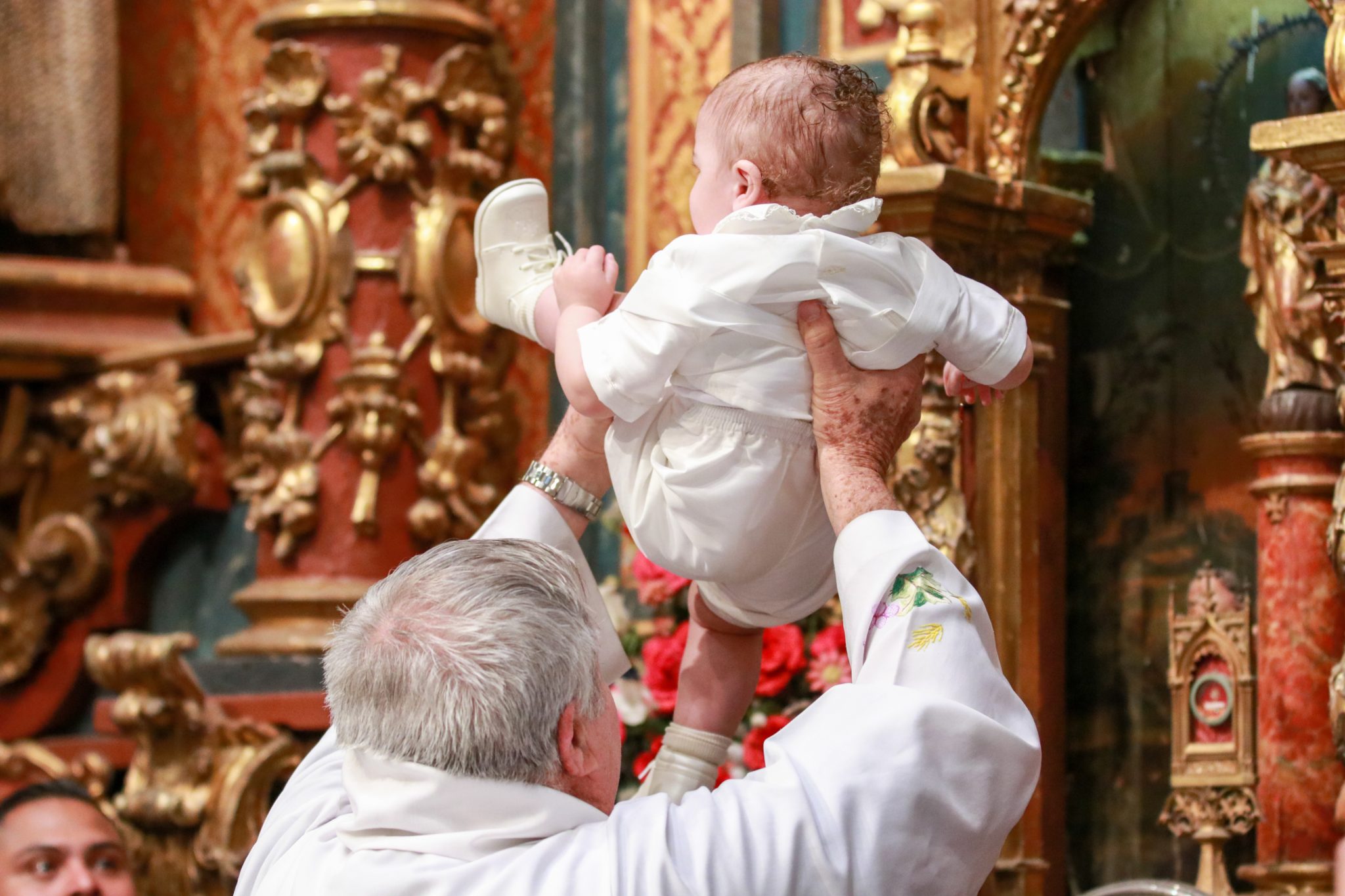 man in white dress shirt carrying baby in white dress
